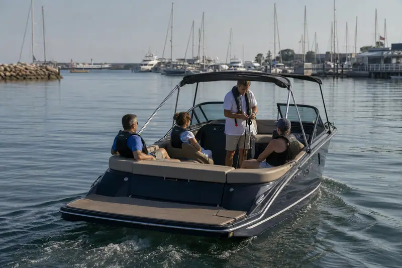 Passagers équipés de gilets de sauvetage sur un bateau de plaisance près d’un port