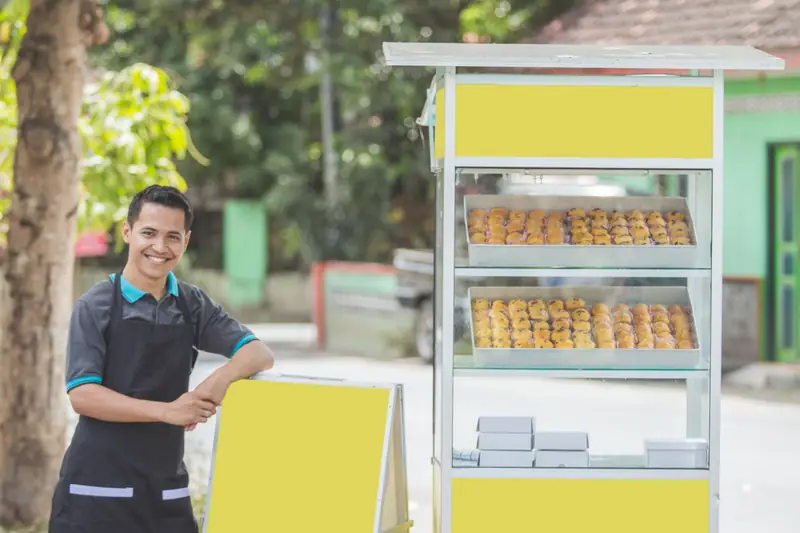 Foodtruck de restauration mobile stationné, avec cuisine professionnelle et vendeur préparant le service