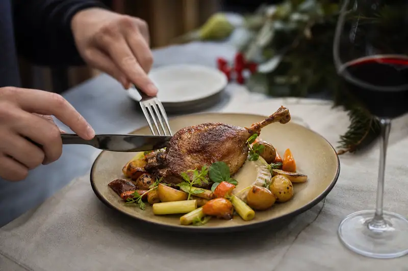 Cuisse de canard confite dorée, légumes racines et pommes grenailles dans une assiette élégante