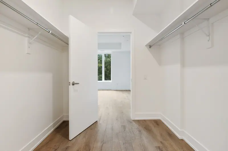 Porte coulissante de placard posée dans une entrée claire avec rangement pour manteaux