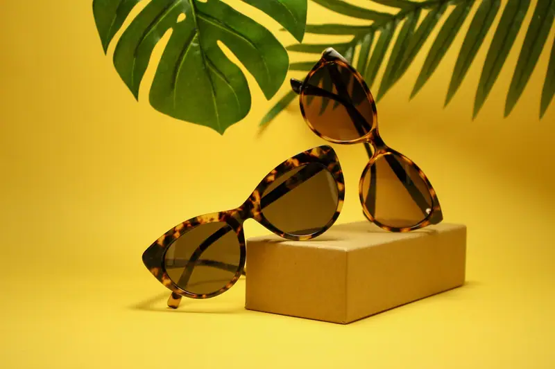 Lunettes de soleil en bois brun posées sur une chemise en lin clair en lumière naturelle