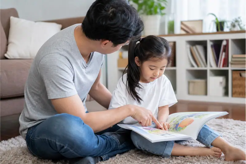 Parent et jeune enfant feuilletant un album illustré et échangeant dans un salon lumineux