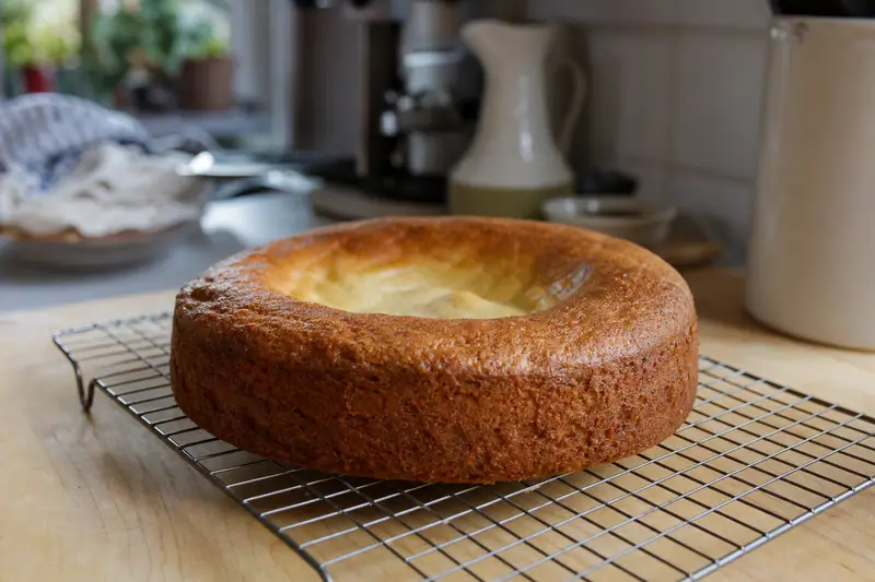 Gâteau affaissé au centre posé sur une grille de refroidissement dans une cuisine