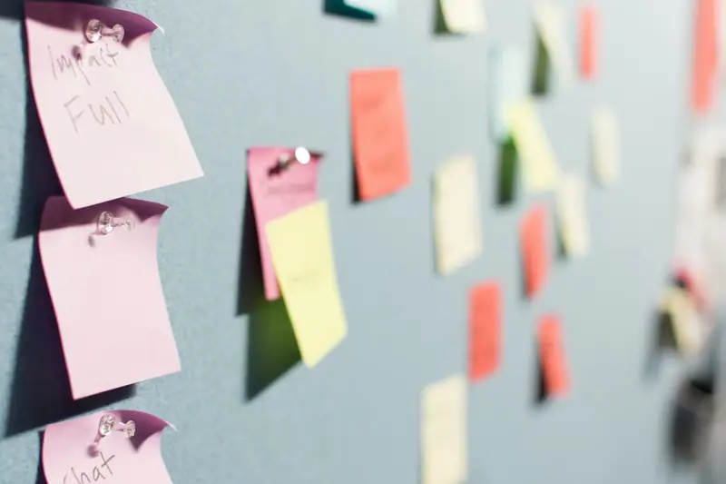 Entrepreneuse préparant des colis d’abonnement dans un atelier lumineux avec produits et cartons