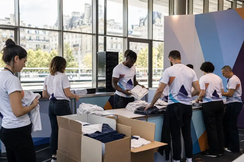 Équipe d’accueil en t-shirts personnalisés préparant un stand lors d’un événement professionnel à Paris