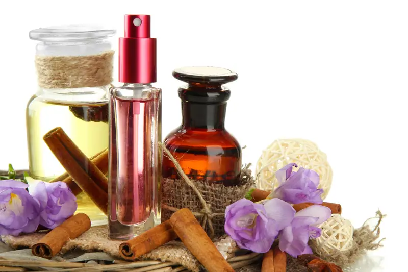 Flacon de parfum blanc sur une coiffeuse avec pétales clairs et bois de cèdre