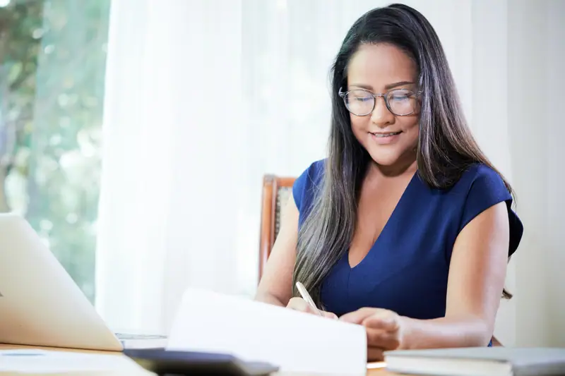 Traductrice relisant un document multilingue avec glossaire et caractères de plusieurs écritures
