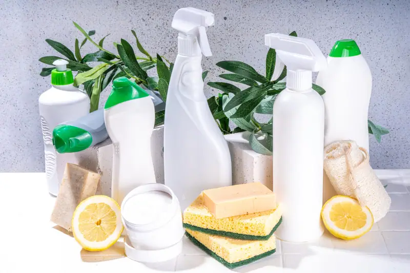 Produits de ménage écologiques avec microfibres, savon et vinaigre sur un plan de travail lumineux