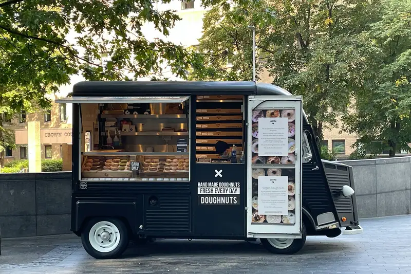 Deux entrepreneurs préparent des commandes dans un foodtruck sur un emplacement de marché