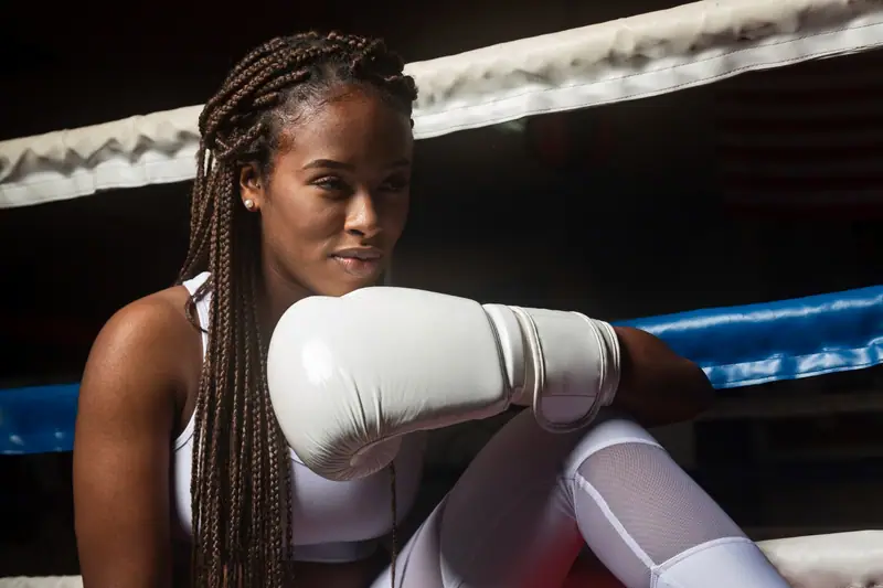 Boxeur retirant ses gants et marchant calmement dans une salle après l’entraînement