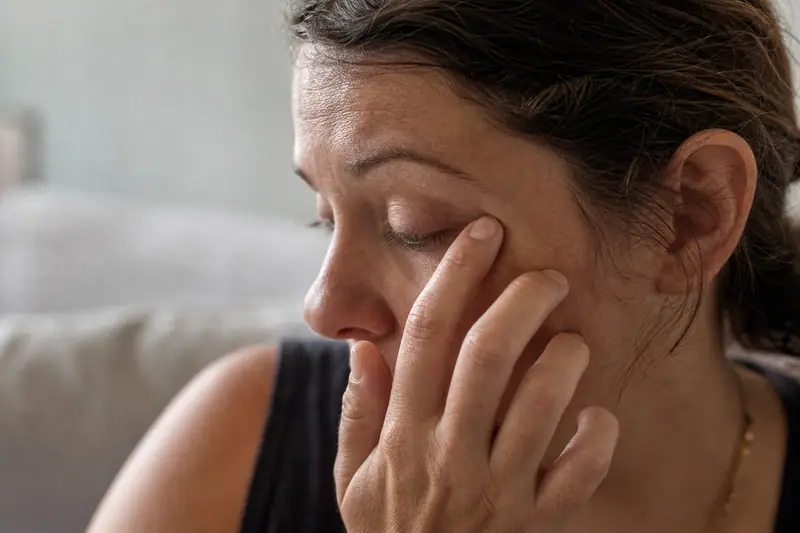 Portrait en gros plan d’une personne fermant légèrement les yeux, expression fatiguée