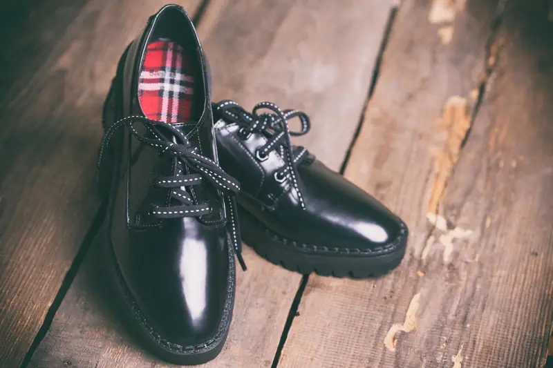 Artisan chaussurier assemblant une chaussure en cuir dans un atelier français lumineux