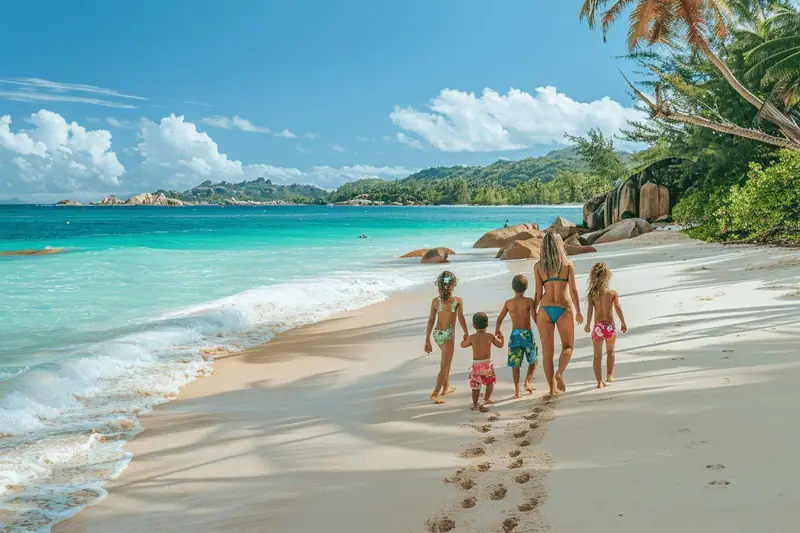 Famille avec deux enfants marchant sur une plage granitique des Seychelles au coucher du soleil